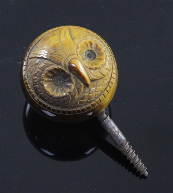 An early 20th century tigers eye quartz cane handle carved with the face of an owl, diameter 1.75in.